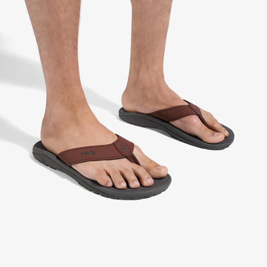 Men's brown and black thong flip-flops with contoured footbeds, shown on feet.