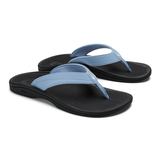 Pair of flip-flops with light blue straps and black soles, shown from a three-quarter view.