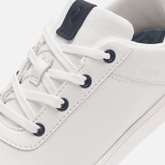 White leather sneaker with dark blue lace eyelets, collar trim, and heel tab.