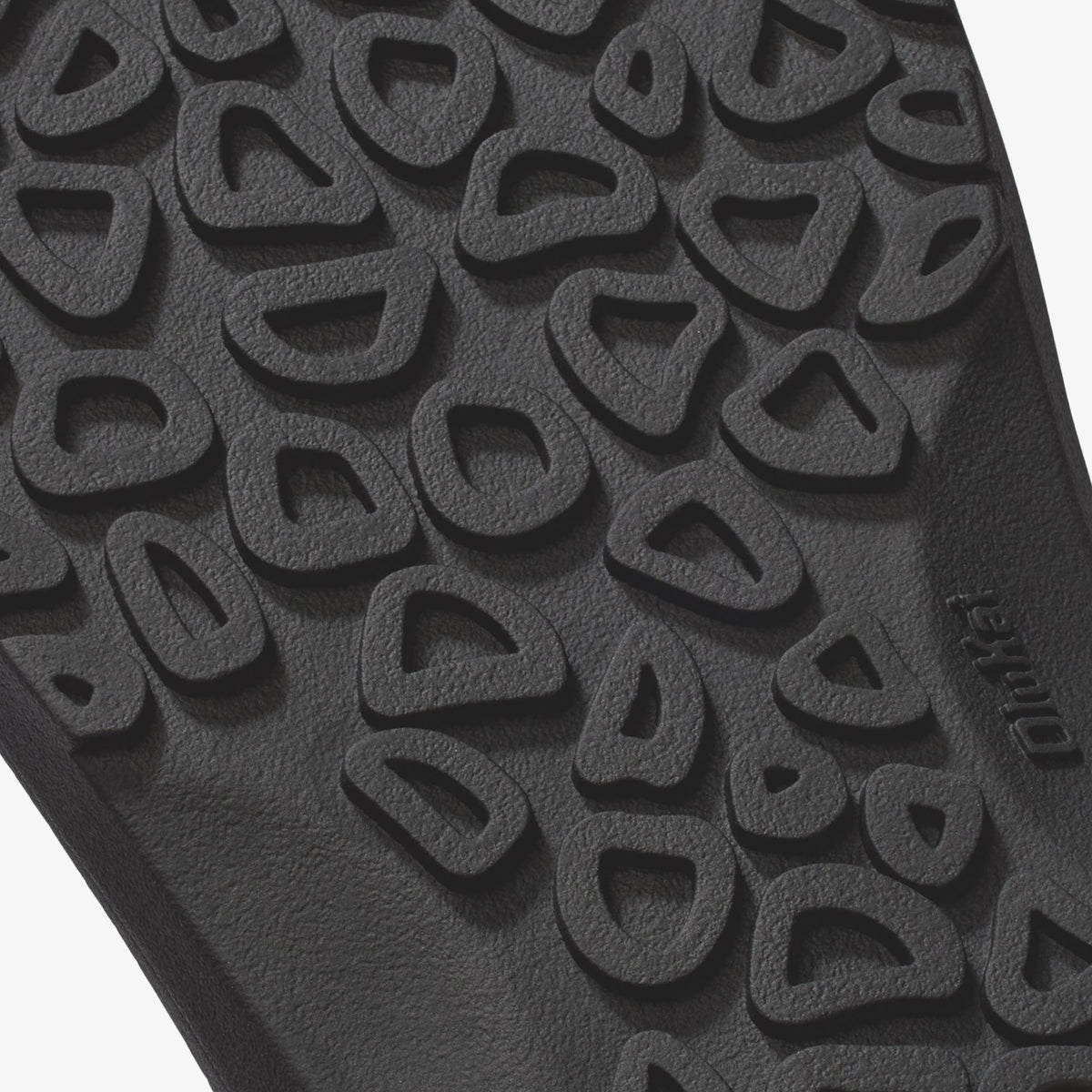 Close-up of textured sole with repeating curved geometric pattern and "native" branding.