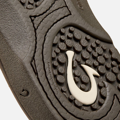 Dark gray slide sole with textured grip pattern and white curved logo detail.