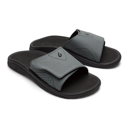 Pair of gray and black slide sandals with perforated details and black sole.