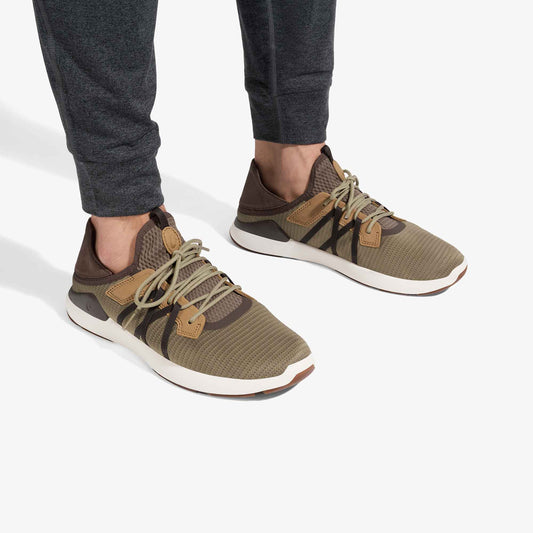 Tan and brown mesh sneakers with lace-up closure and white sole, worn with dark gray pants.