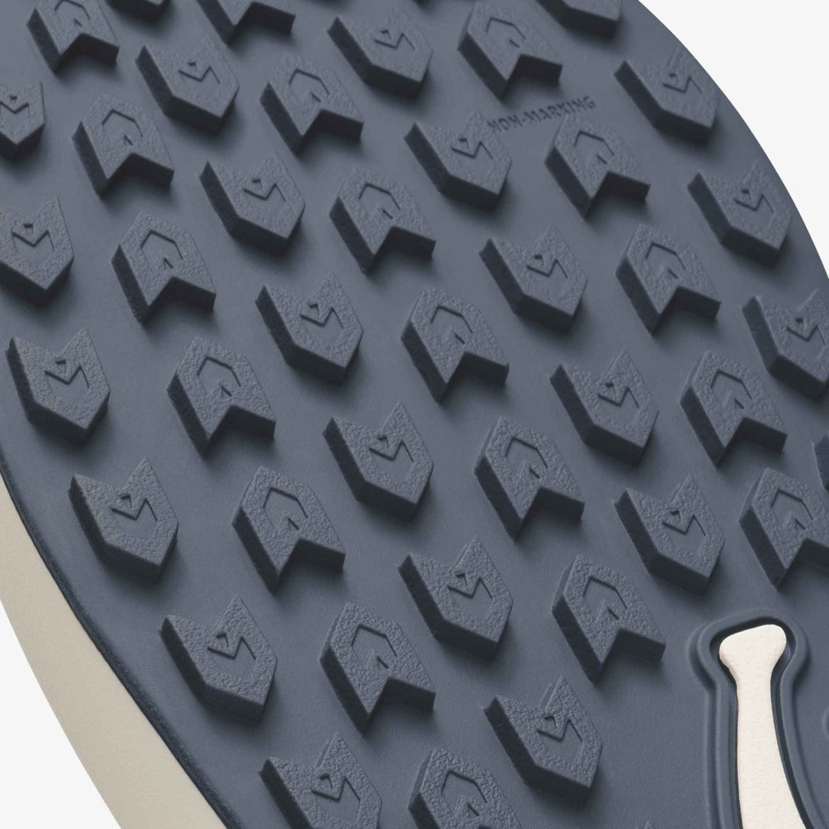 Grey rubber sole with geometric tread pattern and tan heel insert visible at edge.