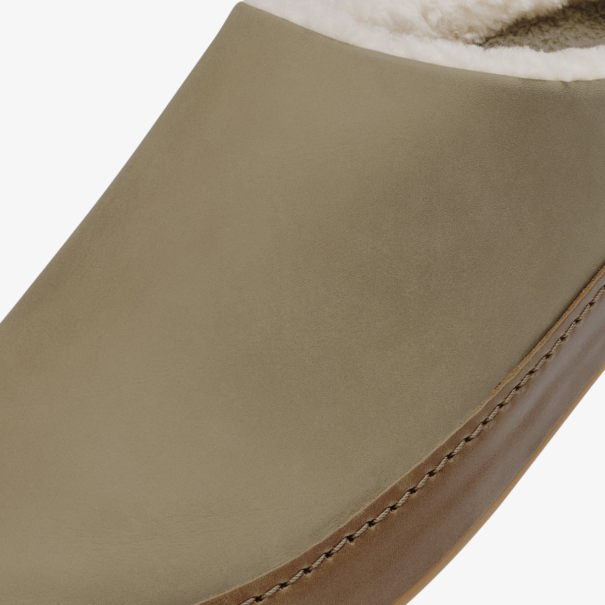 Tan suede slip-on shoe with cream fur collar and tan stitched seam detail along the side.