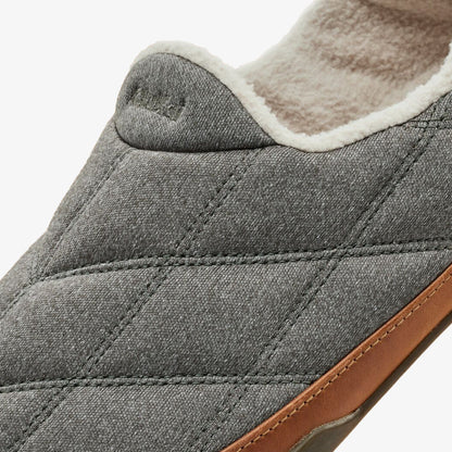 Gray quilted slipper with cream fleece lining and tan leather heel detail, shown from side view.