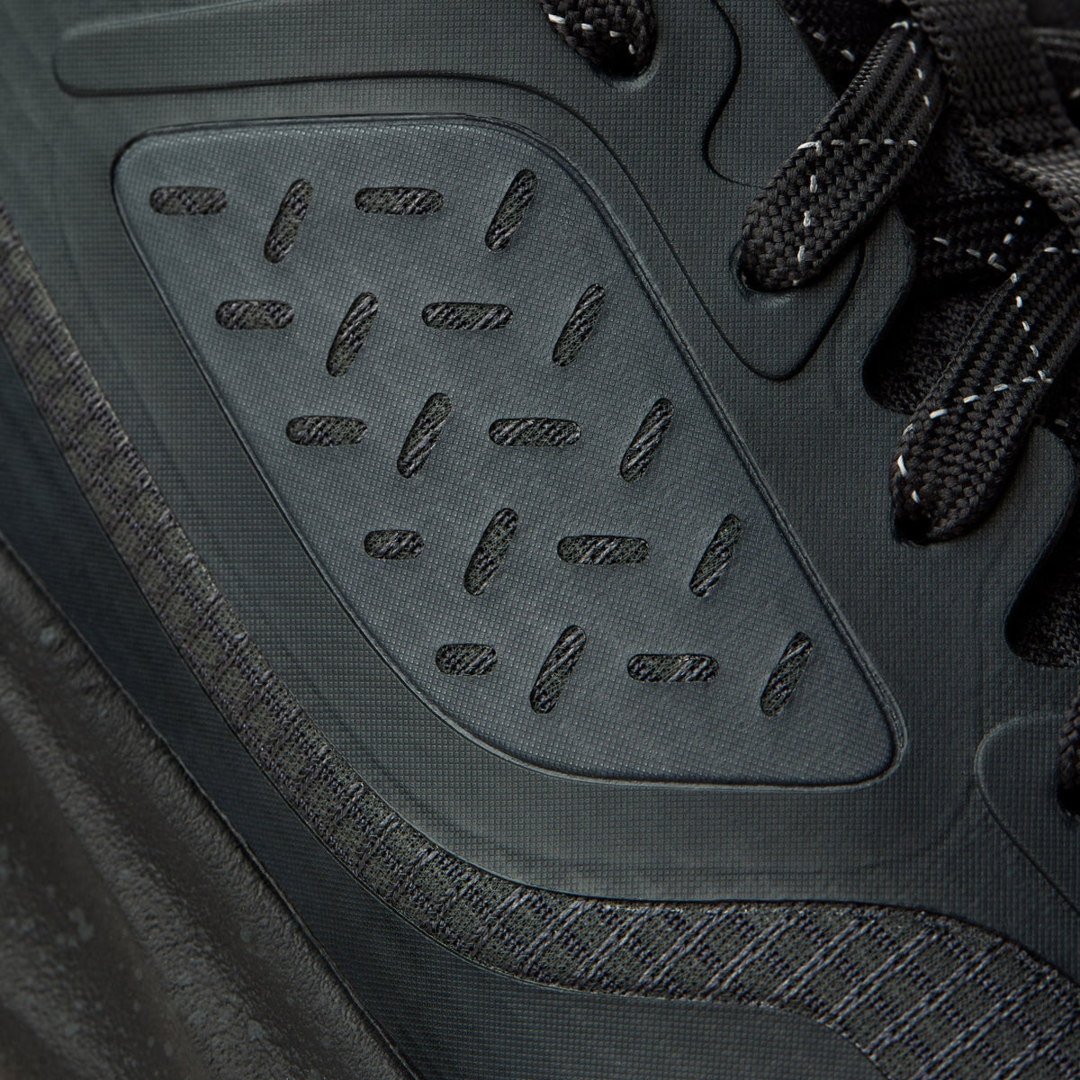 Gray hiking shoe with lava rock-patterned sole, black laces, and textured mesh upper.
