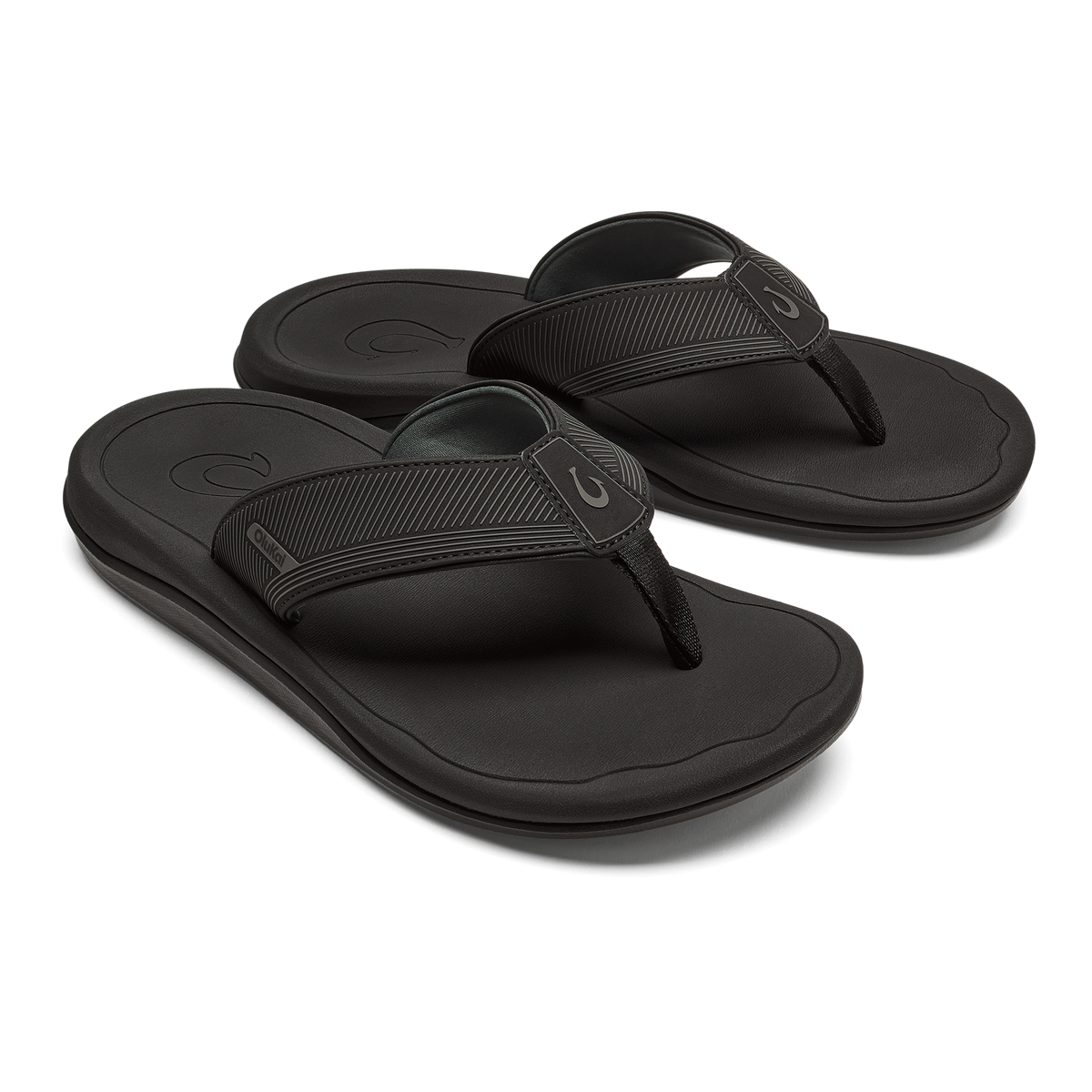 Pair of black thong sandals with textured straps and cushioned soles, shown from a three-quarter view.