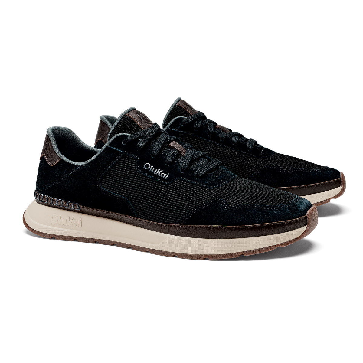 Black lace-up sneaker with textured upper, cream midsole, and brown trim accents.
