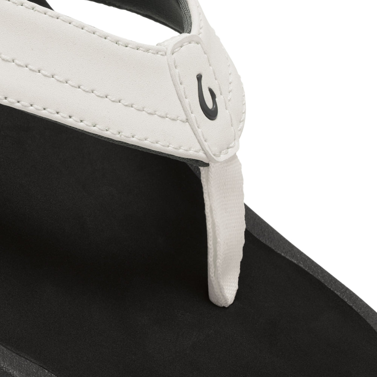 White and black sandal with padded white upper strap and black sole detail.