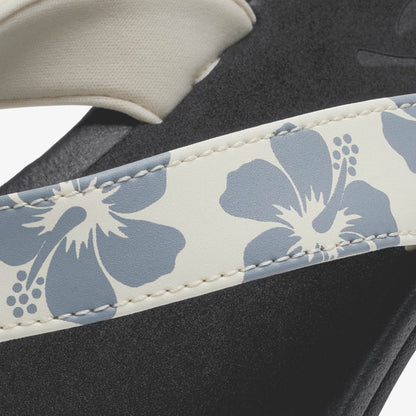 White and blue floral patterned strap on black footwear with cream-colored sole detail.