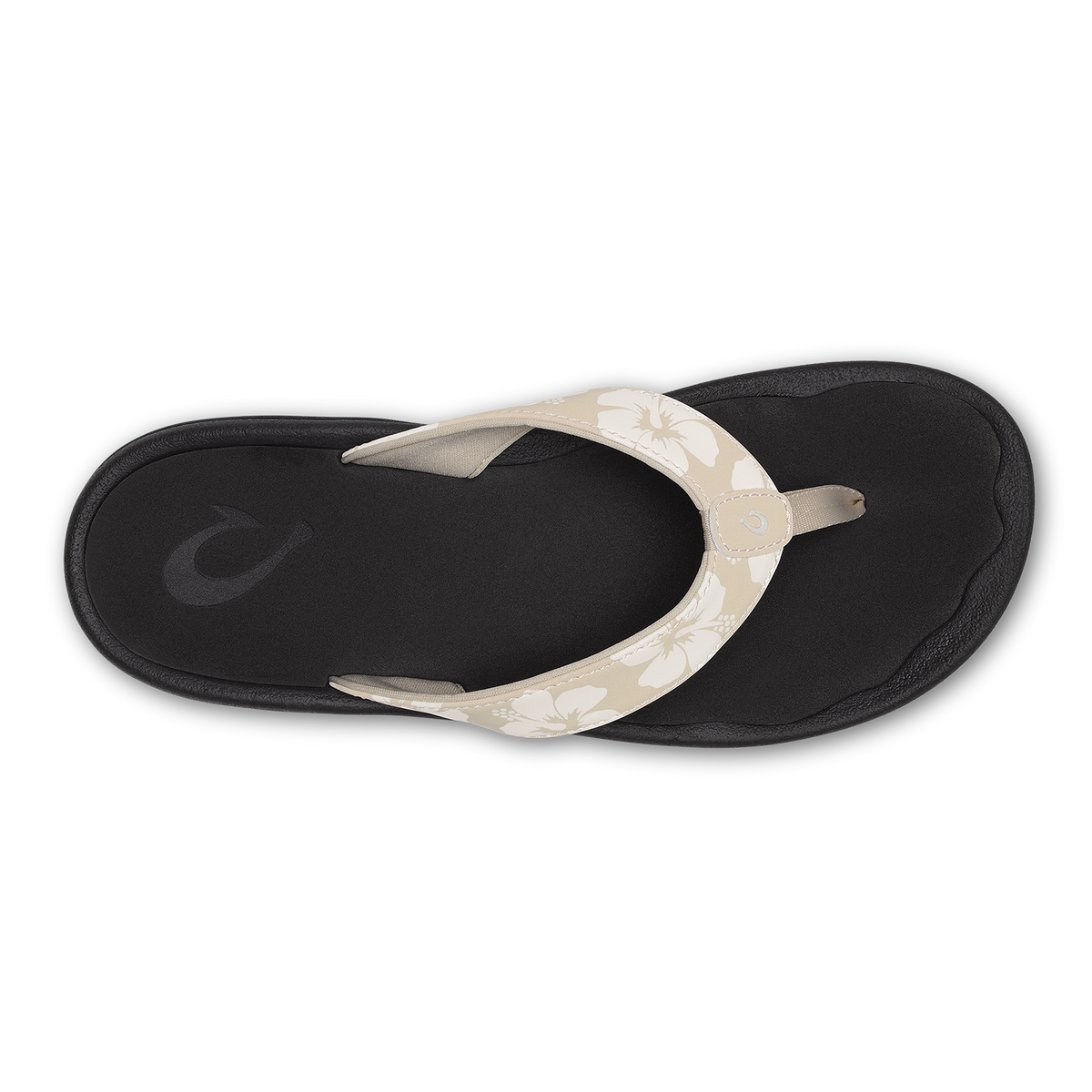 Black flip-flop sandal with cream-colored floral patterned thong strap, viewed from above.