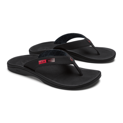 Pair of black thong sandals with contoured footbeds and red accent labels on the straps.