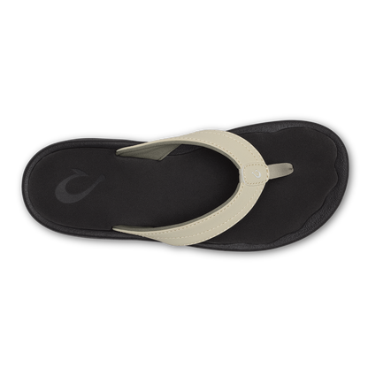 Flip-flop thong sandal with ecru strap and black sole, viewed from above.
