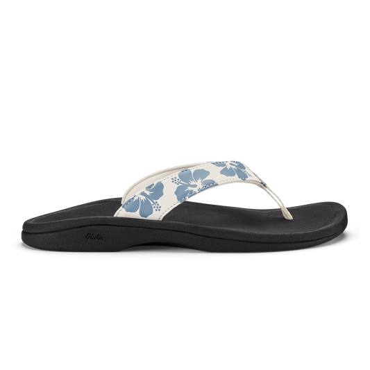 White and blue floral thong sandal with black sole and curved footbed.