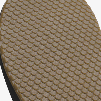 Tan rubber sole with raised grid tread pattern and black heel strip.