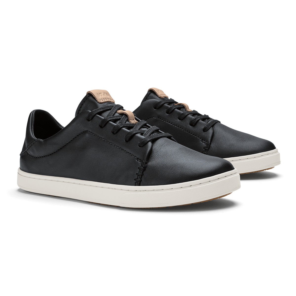 Black leather sneakers with cream rubber sole and tan heel collar detail, shown from side angle.