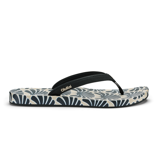 Black and cream flip-flop with geometric fan pattern on sole and black fabric thong strap.