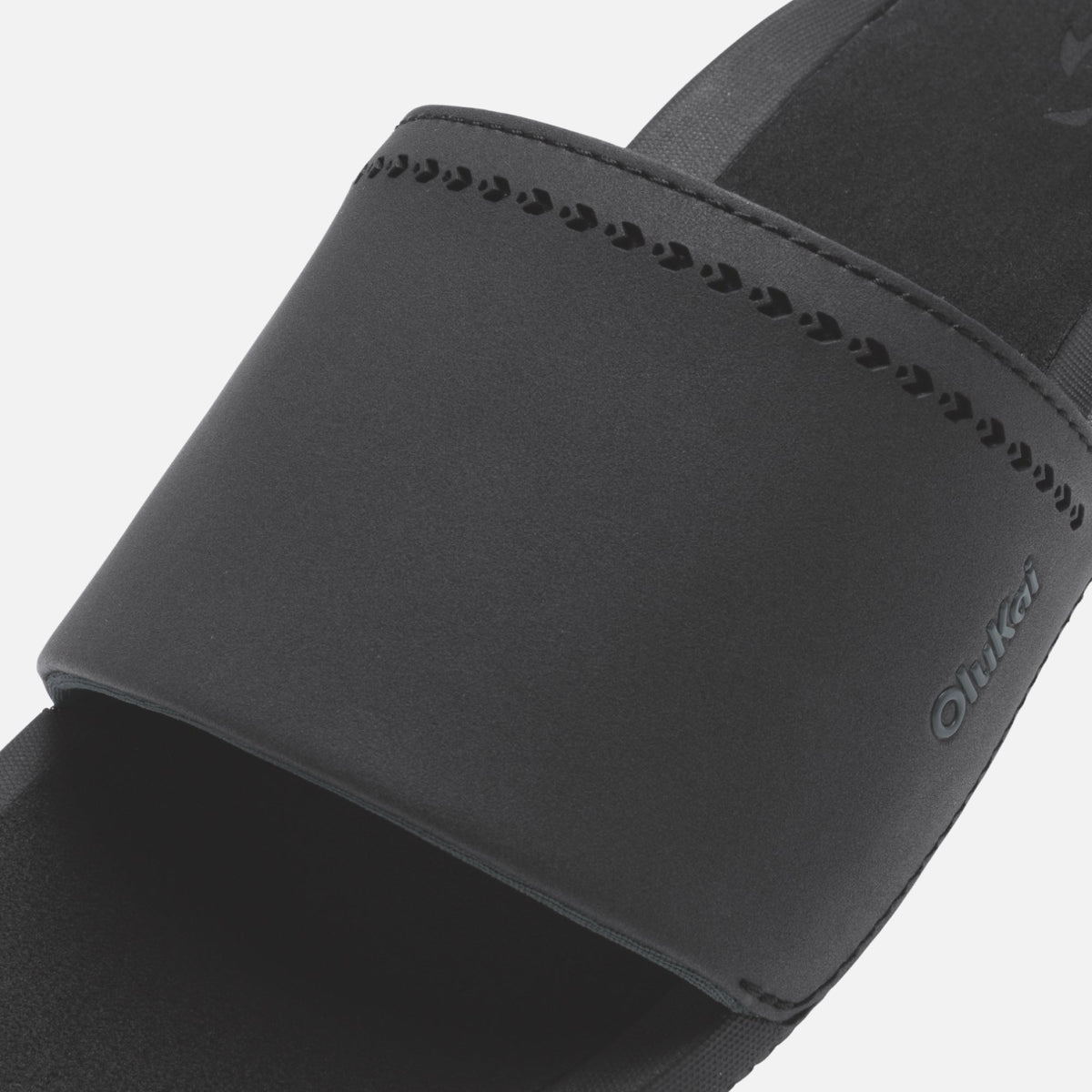 Black slide sandal with textured footbed and adjustable fabric strap.
