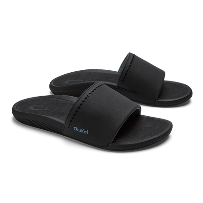 Black slide sandals with padded straps and textured soles, shown from a front angle view.