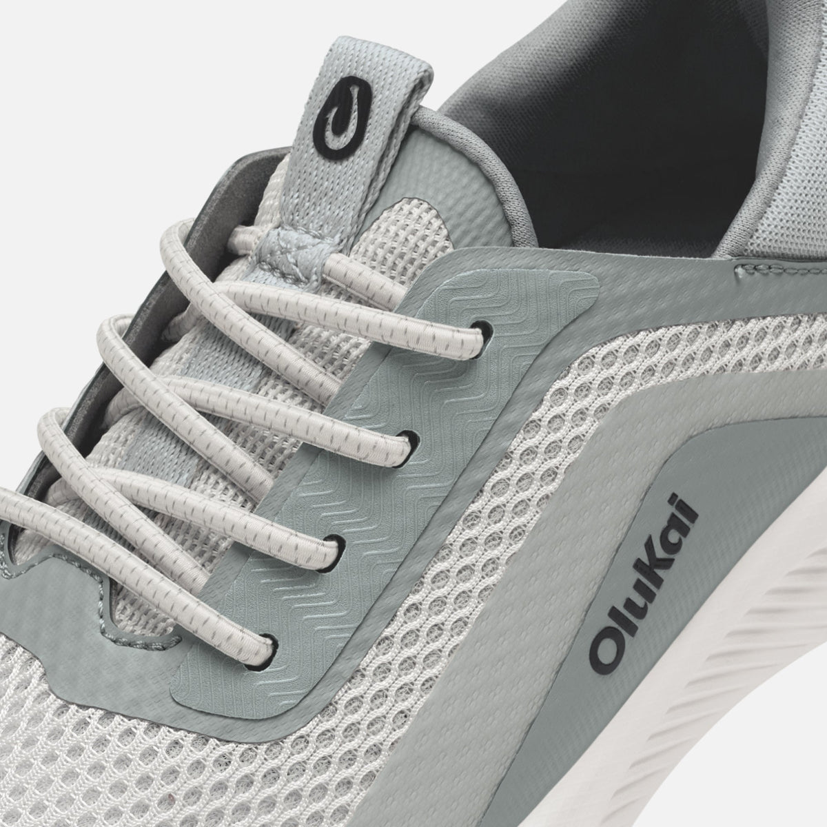 Gray and white athletic shoe with white laces, mesh panels, and Oiikai branding on the side.