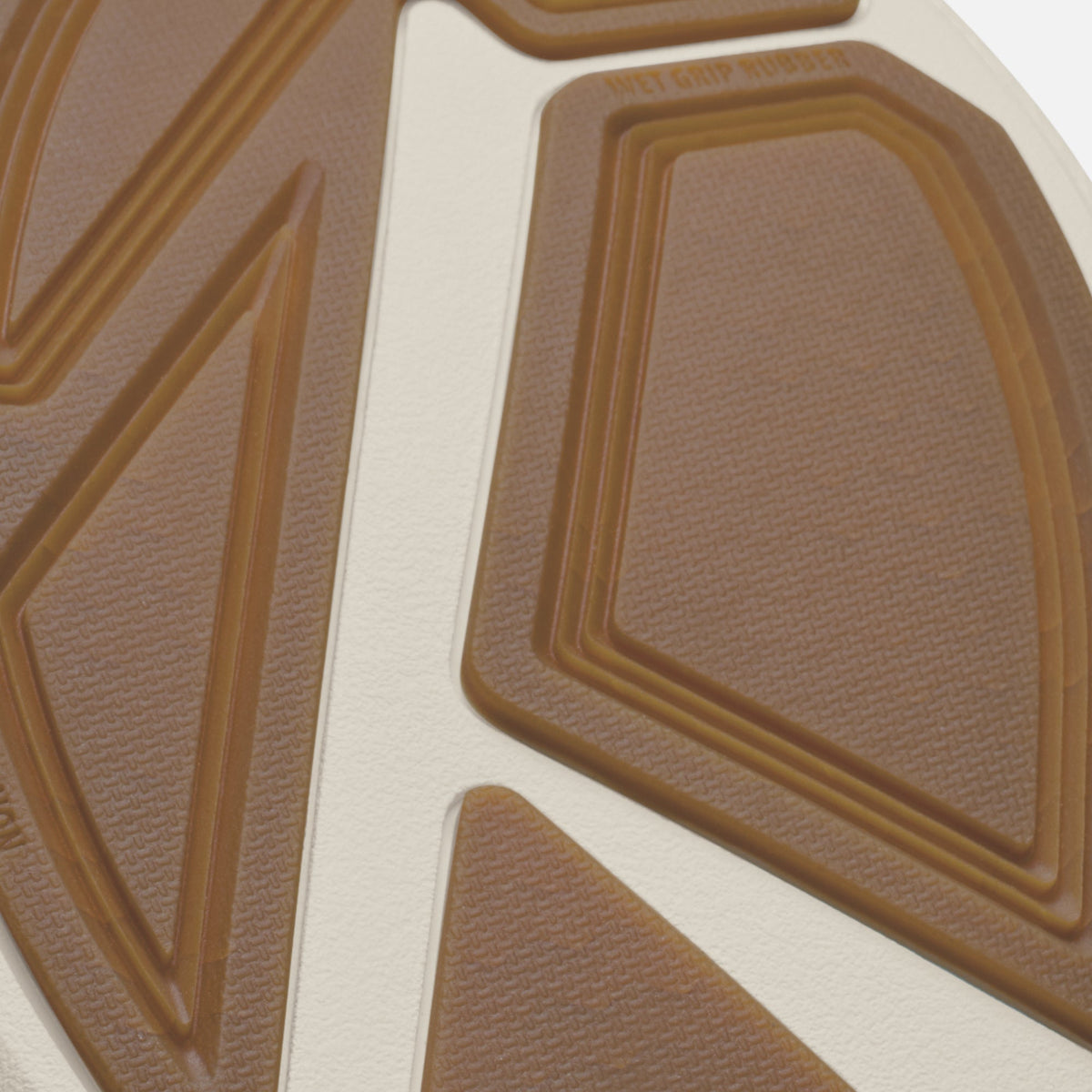 Close-up of tan and cream colored paddle deck with geometric raised patterns and textured surface.