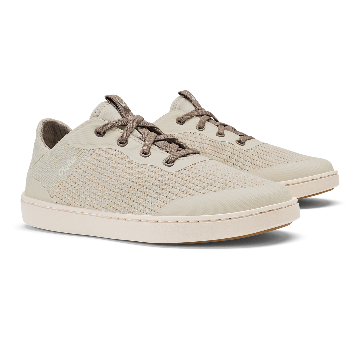 Cream-colored lace-up sneaker with brown laces, perforated upper, and cream sole, shown from a three-quarter view.