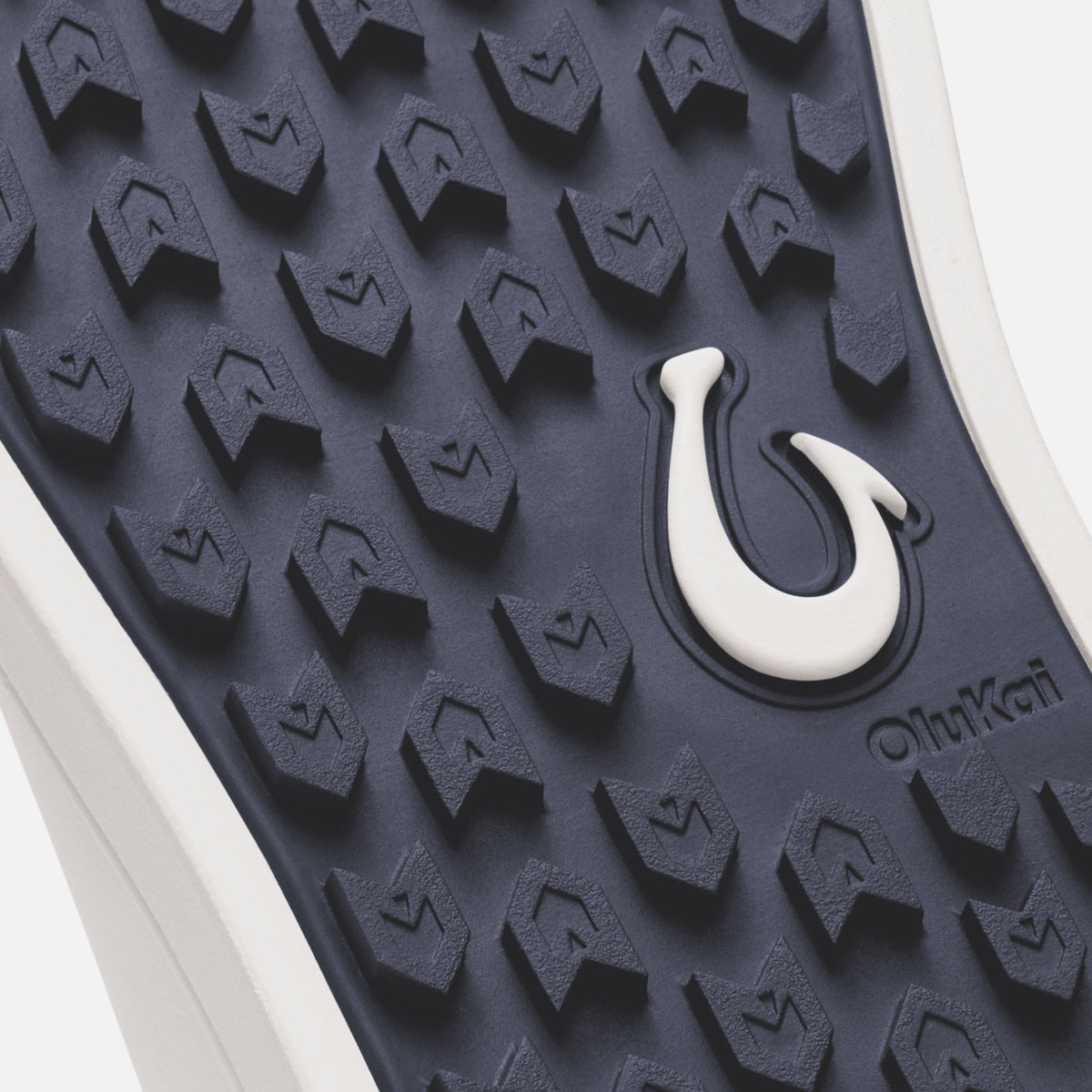 Trench blue sole with bright white hook detail and textured tread pattern.