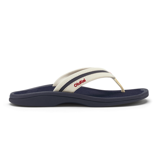 White and navy thong sandal with padded footbed and red text on the strap.