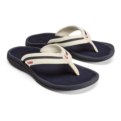 Pair of thong sandals with navy blue footbeds, white straps, and red logo detail on the heel.