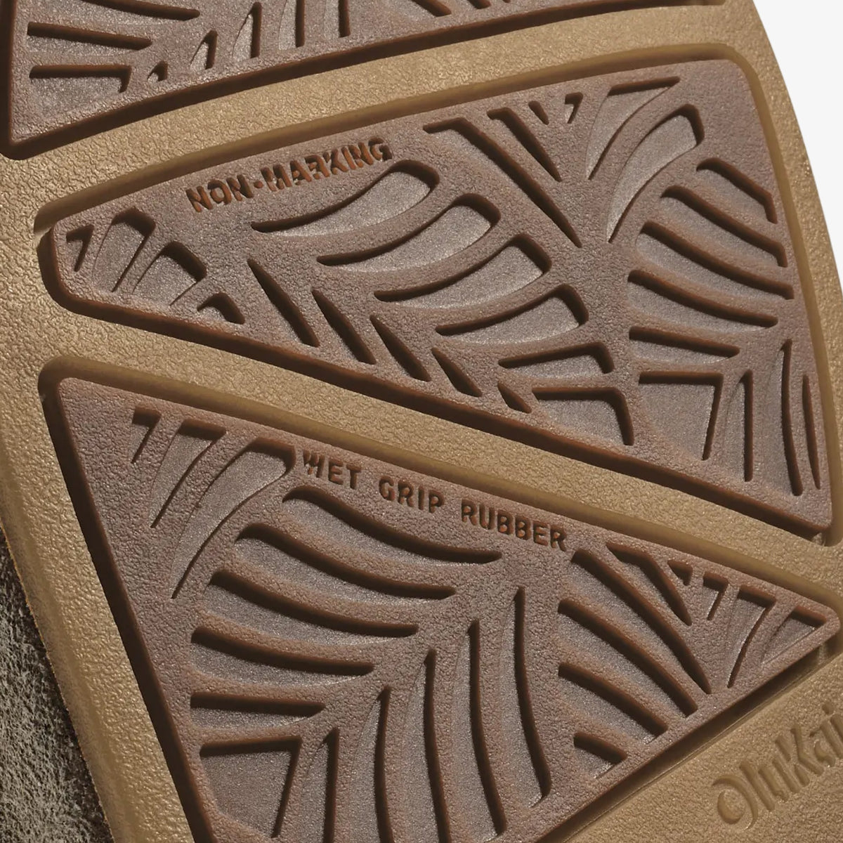 Close-up of sole showing walnut and dark java colored rubber with geometric tread pattern and text details.