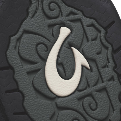 Black textured surface with white hook symbol and embossed tribal-style pattern detail.