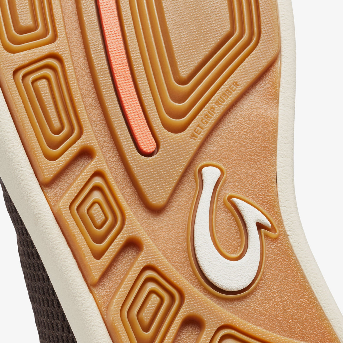 Tan and white slip-on shoe sole with geometric tread pattern and coral accent stripe.