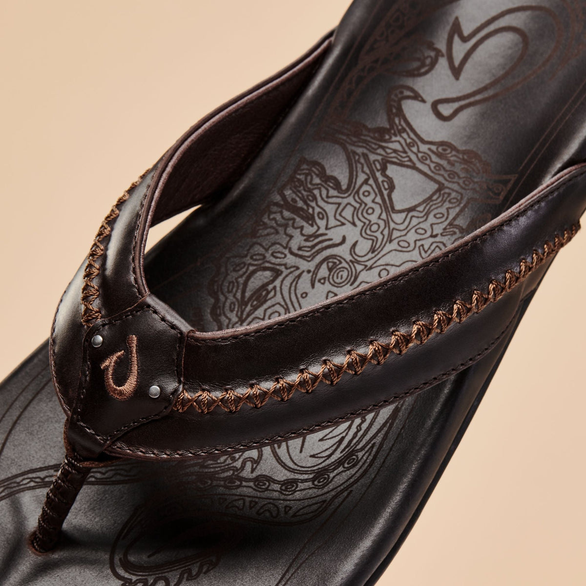 Dark brown leather flip-flop with decorative embroidered strap and patterned footbed detail.