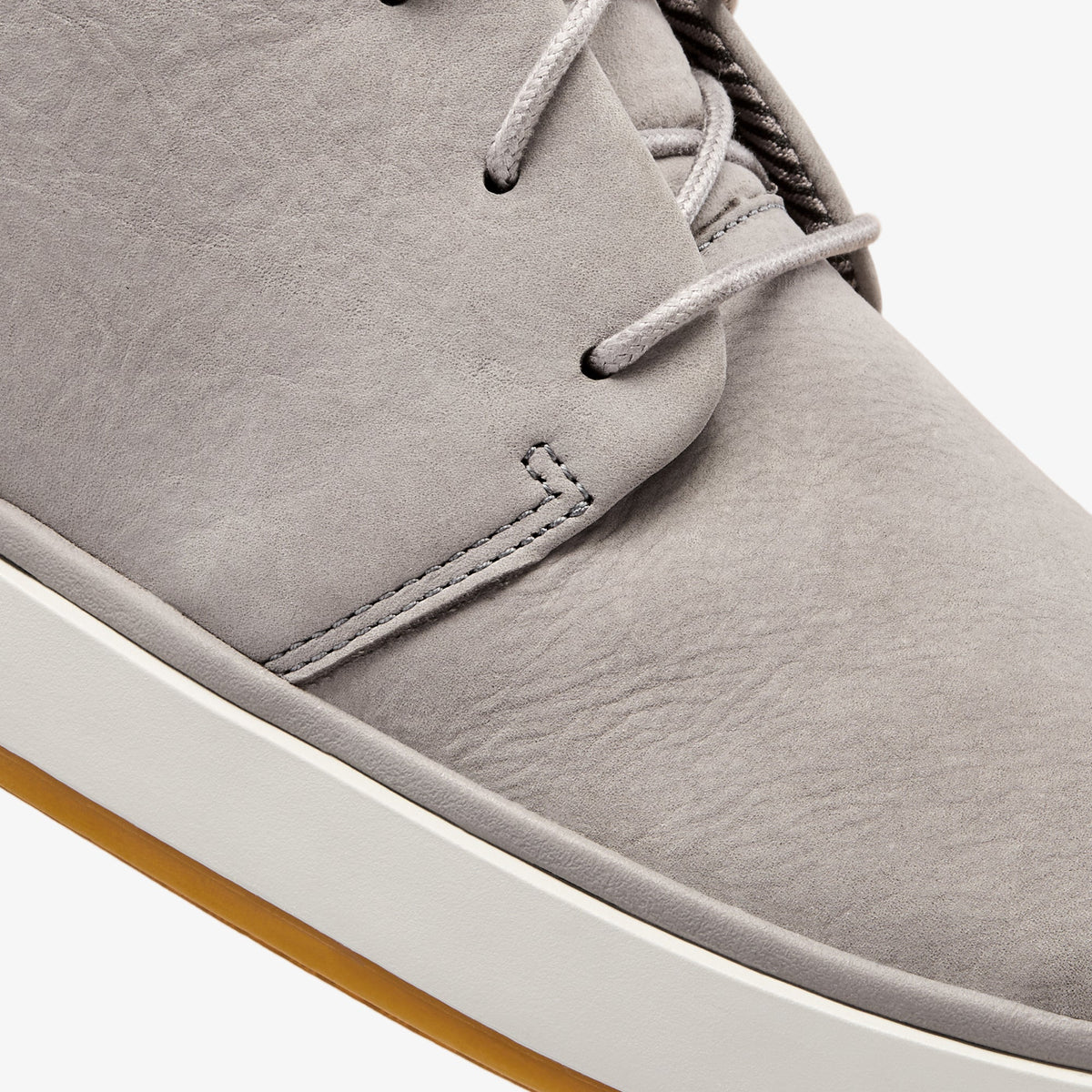 Graphite suede chukka boot with lace-up closure, cream sole, and tan crepe outsole.